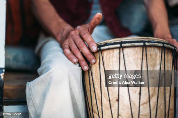 close up of drum head with person's hand - alex drumming 個照片及圖片檔