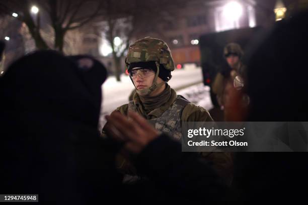Demonstrators confront National Guard troops outside of the Kenosha County Courthouse as they protest the announcement by District Attorney Michael...