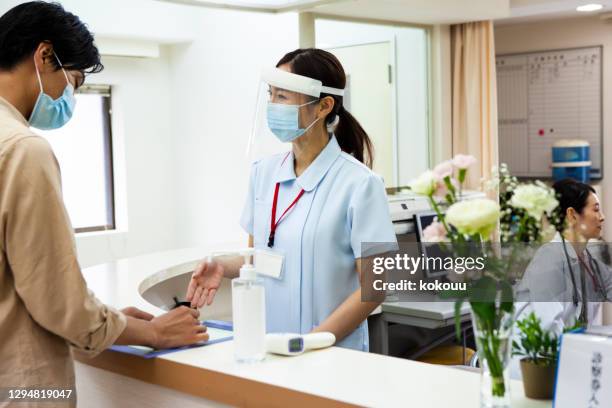 a woman at the hospital reception - covid-19 guidance stock pictures, royalty-free photos & images