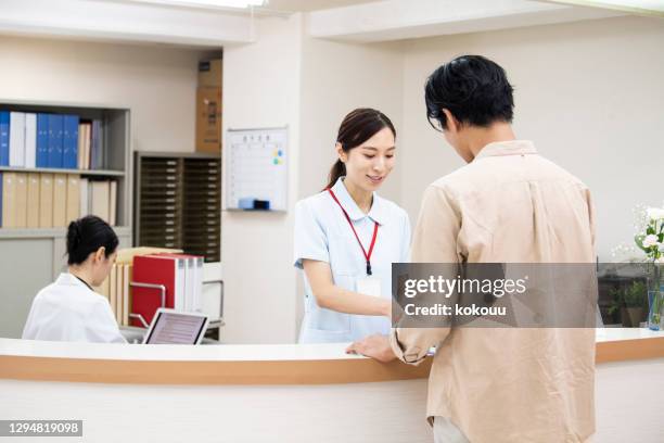 uma mulher na recepção do hospital. - posto das enfermeiras - fotografias e filmes do acervo