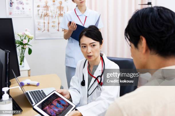 female doctor examining a male patient - medical examination room stock pictures, royalty-free photos & images
