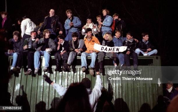 Revelers at the Brandenburg Gate stand on pubilc toilet beside of a remnant of the Berlin Wall, as they celebrate the first New Year in a unified...