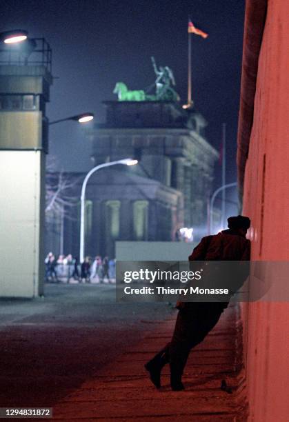 VoPo is talking to someone through a hole in a remnant of the Berlin Wall near by the Brandenburg Gate during the celebration of the first New Year...