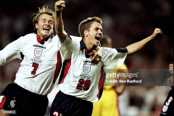 Michael Owen of England celebrates with team mate David Beckham after scoring in the World Cup group G game against Romania at the Stade Municipal in...