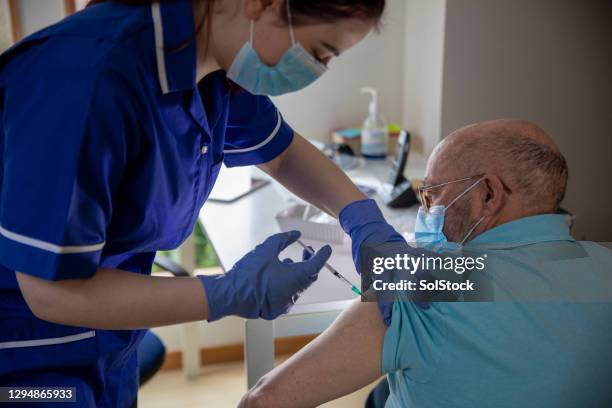 being vaccinated against covid 19 - coronavirus nurse stock pictures, royalty-free photos & images