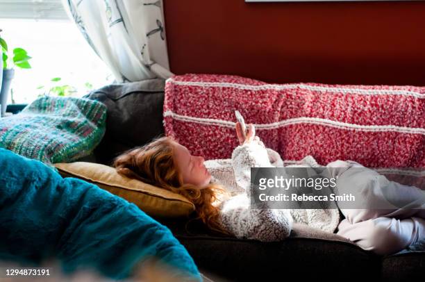 teen child alone on couch - american girl alone stock-fotos und bilder