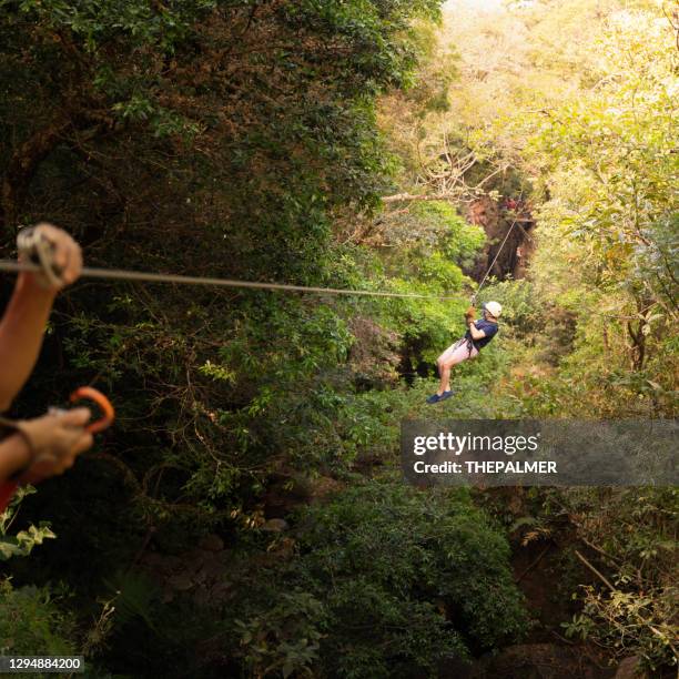 latin man on a canopy tour in costa rica - costa rica zipline stock pictures, royalty-free photos & images