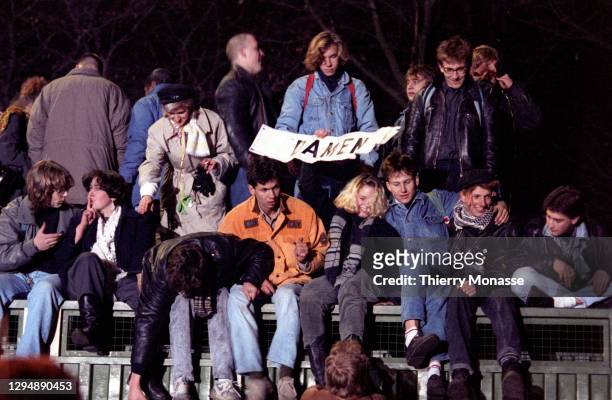 Revelers at the Brandenburg Gate stand on pubilc toilet beside of a remnant of the Berlin Wall, as they celebrate the first New Year in a unified...