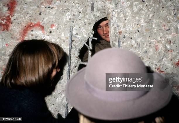 An east Deutsche Volkspolizei talks with some woman through the Berlin wall during the New-Year Eve on December 31, 1989 in Berlin, Germany.