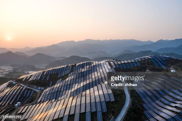 aerial view of the solar power plant on the top of the mountain at sunset - herstellendes gewerbe stock-fotos und bilder