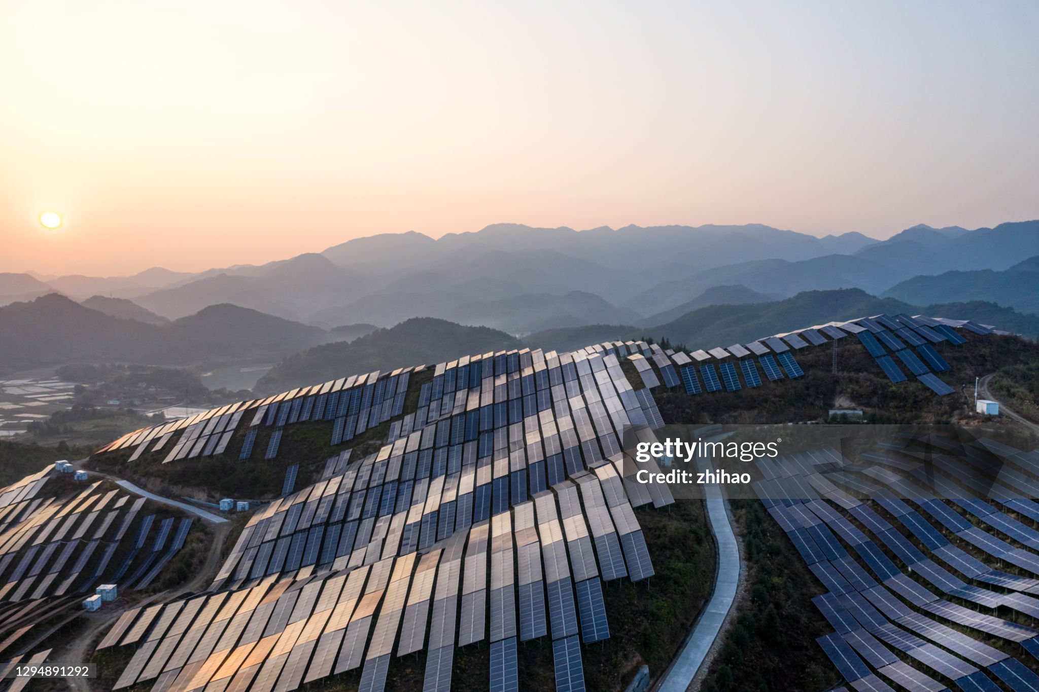 Aerial view of the solar power plant on the top of the mountain at sunset