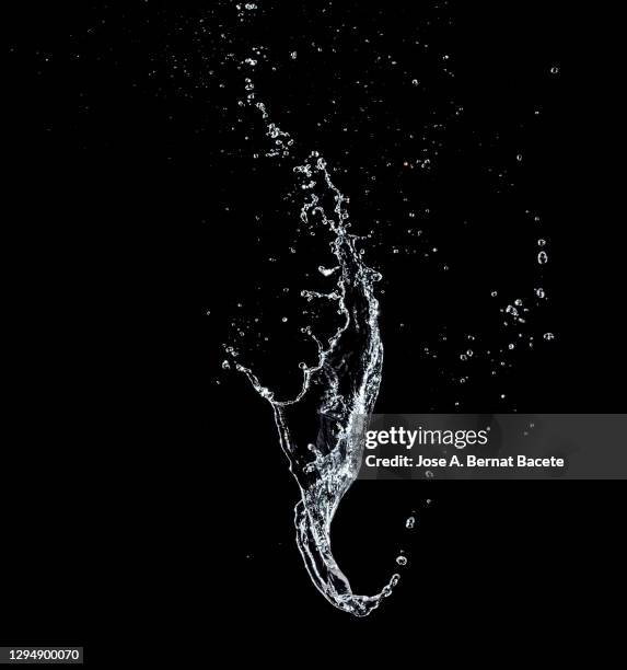 splashes, jet and drops of water in motion suspended in the air on a black background. - spritzendes wasser stock-fotos und bilder