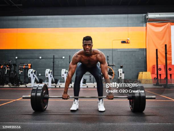 man working out in a gym with barbell and weights - muscular black guy stock pictures, royalty-free photos & images