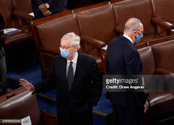 Senate Majority Leader Mitch McConnell and Senate Minority Leader Chuck Schumer stand back to back in the House Chamber during a joint session of...