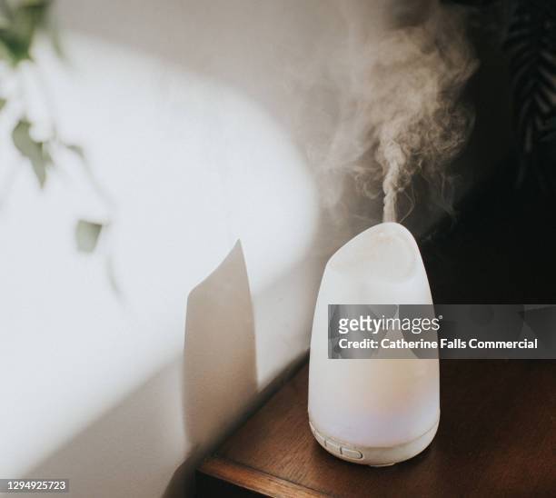 a white oil diffuser / humidifier in a domestic setting - aromatherapy stock pictures, royalty-free photos & images