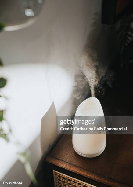 a white oil diffuser / humidifier in a domestic setting - aromatherapy diffuser stock pictures, royalty-free photos & images
