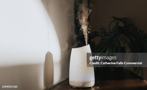 a white oil diffuser / humidifier in a domestic setting - air freshener stock pictures, royalty-free photos & images