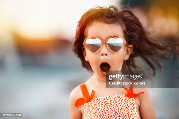 niña bebé sorprendida usando gafas en forma de corazón - an evening with heart fotografías e imágenes de stock