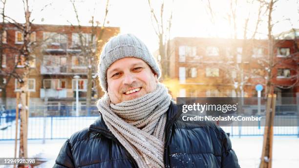 mature man dressed for deep winter urban portrait back lit by sunset - toque stock pictures, royalty-free photos & images