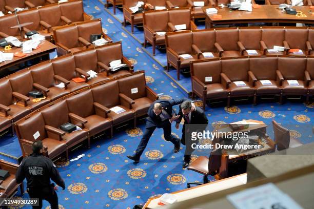 Members of congress run for cover as protesters try to enter the House Chamber during a joint session of Congress on January 06, 2021 in Washington,...
