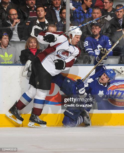 Mike Brown of the Toronto Maple Leafs is checked by Ryan Wilson of the Colorado Avalanche during NHL game action October 17, 2011 at Air Canada...