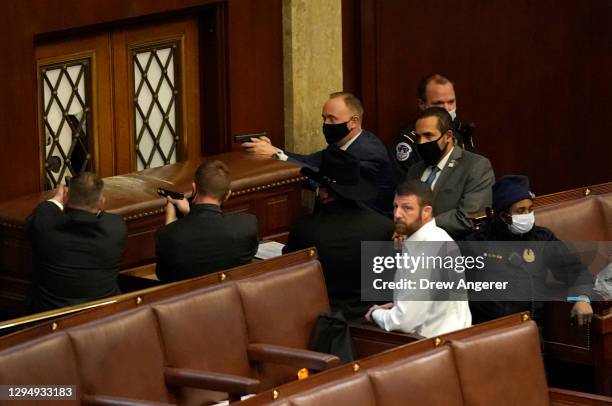 Capitol police officers point their guns at a door that was vandalized in the House Chamber during a joint session of Congress on January 06, 2021 in...