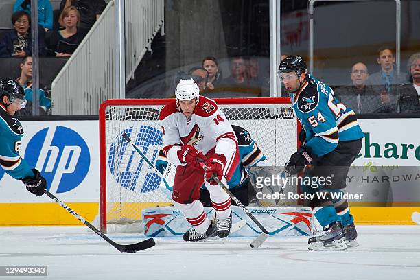 Left wing Taylor Pyatt of the Phoenix Coyotes goes for the puck against defenseman Justin Braun and defenseman Nick Petrecki of the San Jose Sharks...