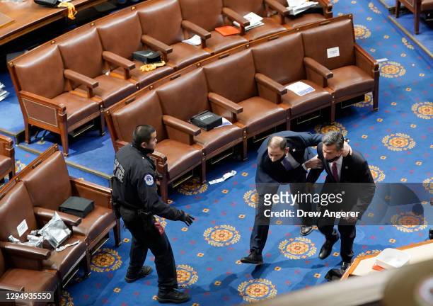 Members of congress run for cover as protesters try to enter the House Chamber during a joint session of Congress on January 06, 2021 in Washington,...