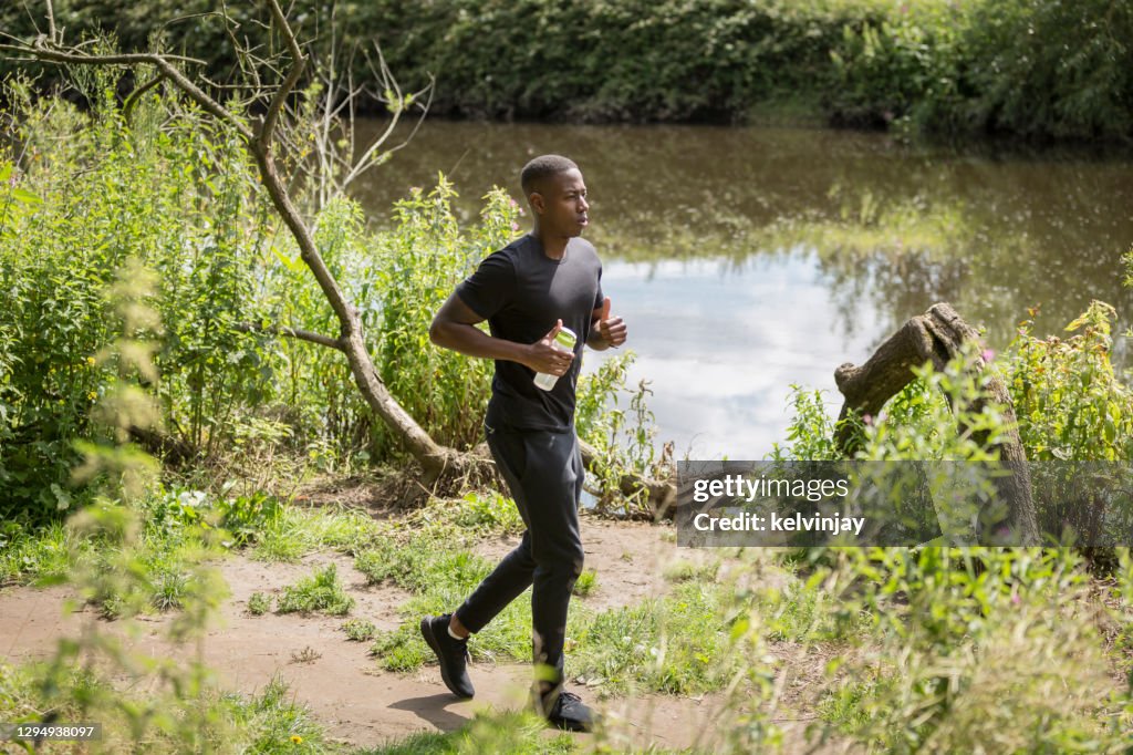 Young man running by river