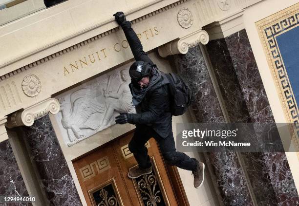 Protester supporting U.S. President Donald Trump jumps from the public gallery to the floor of the Senate chamber at the U.S. Capitol Building on...