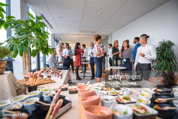 tables of gourmet sweet and savory food at office party - office party stock pictures, royalty-free photos & images