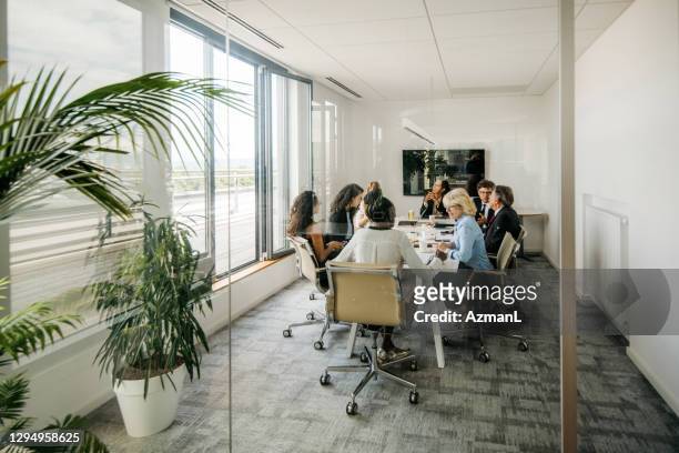 executive team meeting photographed through window - board room stock pictures, royalty-free photos & images