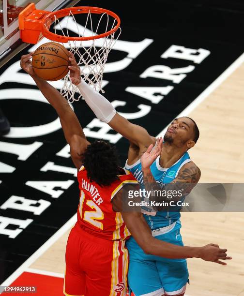Washington of the Charlotte Hornets blocks a dunk attempt by De'Andre Hunter of the Atlanta Hawks during the first half at State Farm Arena on...