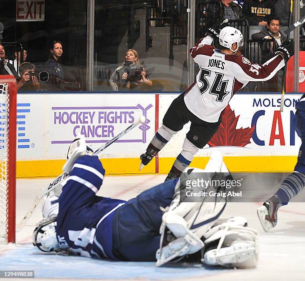 James Reimer of the Toronto Maple Leafs lies on the ice as David Jones of the Colorado Avalanche celebrates his over time game winning goal during...