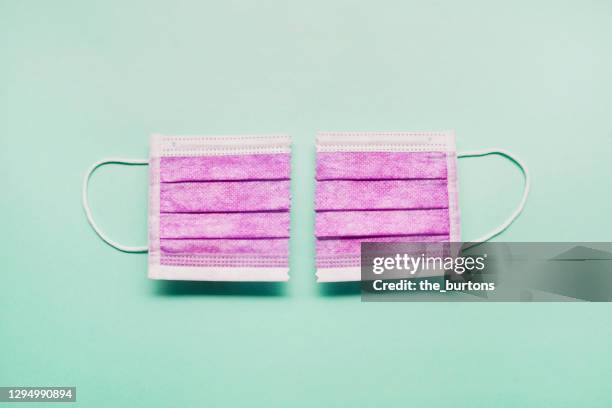 still life of a surgical mask cut to pieces on green background, the pandemic is over - end to end solution stock pictures, royalty-free photos & images