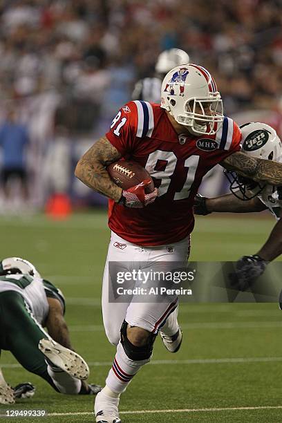 Tight end Aaron Hernandez of the New England Patriots makes a long gain against the New York Jets at Gillette Stadium on October 9, 2011 in Foxboro,...