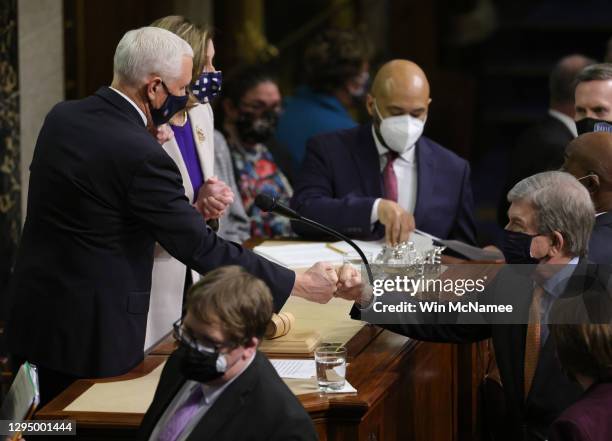 Vice President Mike Pence bumps fists with U.S. Sen. Roy Blunt at the conclusion of the count of electoral votes in the House Chamber during a...