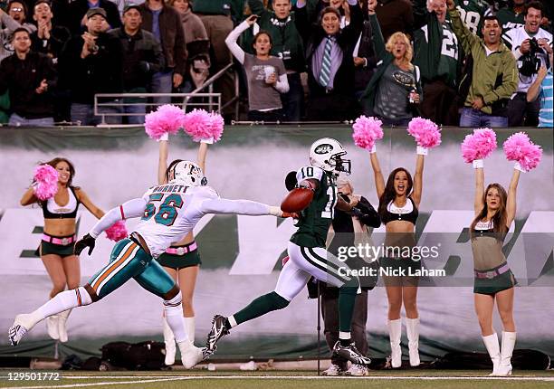 Santonio Holmes of the New York Jets scores a touchdown in the fourth quarter against Kevin Burnett of the Miami Dolphins at MetLife Stadium on...