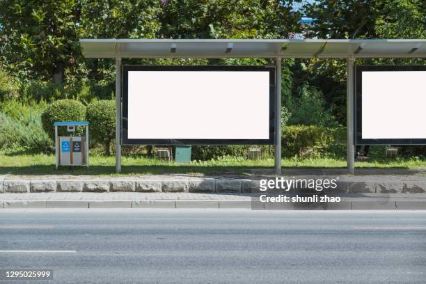 billboard on the roadside - bushaltestelle stock-fotos und bilder
