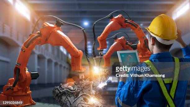 engineer control and check robotics automatic arms machine welding in intelligent factory automotive industrial with tablet monitoring system software. digital manufacturing operation, new industry 4g - auto tablet stockfoto's en -beelden