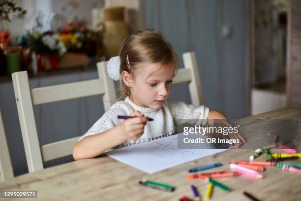 blond girl drawing at wooden table at home - kid with markers 個照片及圖片檔