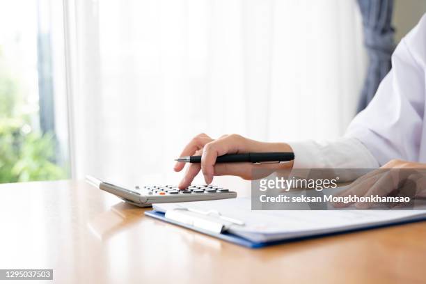woman considers on calculator in office - libro mastro foto e immagini stock