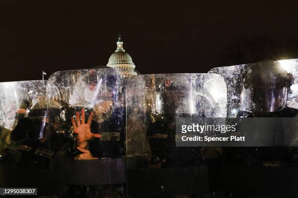 Members of the National Guard and the Washington D.C. Police keep a small group of demonstrators away from the Capital after thousands of Donald...
