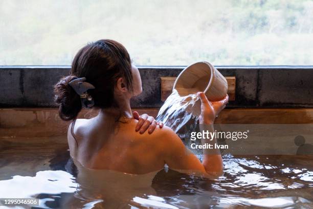 Asian Young Woman in Japanese Style Hot Spring Pool with Naked Back