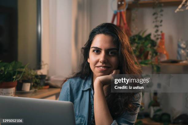 young adult woman sitting in living room - povo turco imagens e fotografias de stock