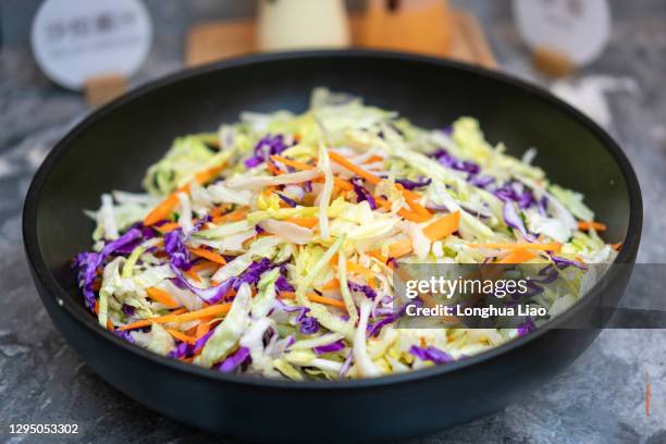 vegetable salad in a black bowl - coleslaw stock pictures, royalty-free photos & images