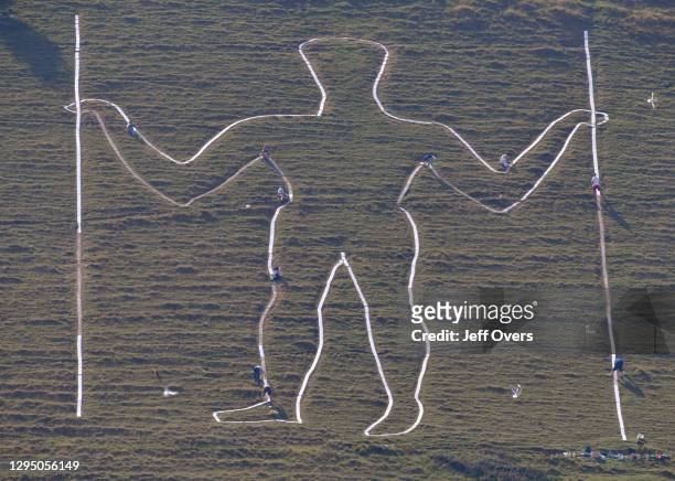 The historic giant hill figure "Long Man of Wilmington" receives a fresh paint from James Neal of the Sussex Archaeological Society and his party of...