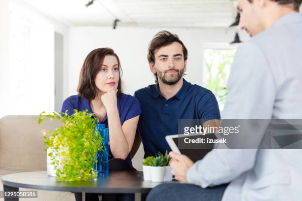 couple discussing with financial advisor - choosing insurance stock pictures, royalty-free photos & images