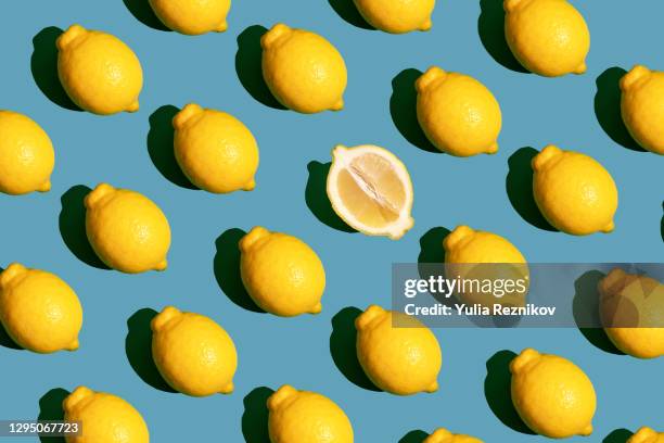 repeated lemon and halved lemon on the green background - agrumi foto e immagini stock