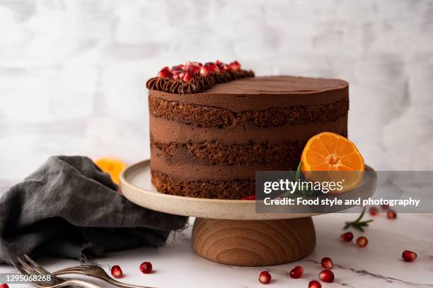 chocolate cake with pomegranate, tangerines and rosemary - chocolate cake stock pictures, royalty-free photos & images